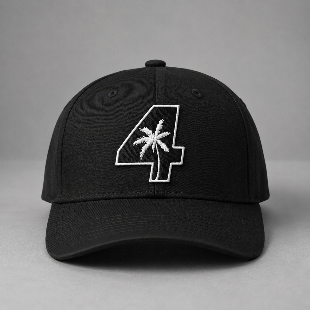 A black U4RIA fitted baseball cap with a white embroidered number 4 containing a palm tree design on the front, set against a neutral grey background.
