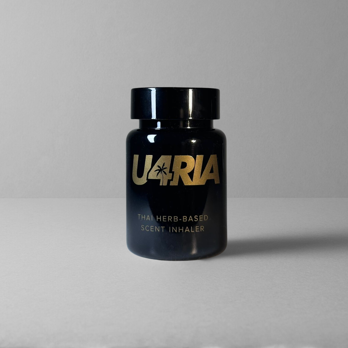 A glossy black U4RIA bottle with a black cap, featuring gold lettering that reads 'U4RIA' on a light grey background.