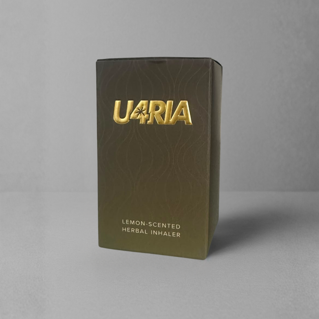 A rectangular yellow-black gradient box for a U4RIA lemon-scented herbal inhaler, featuring a metallic gold logo and text, set against a neutral grey background.