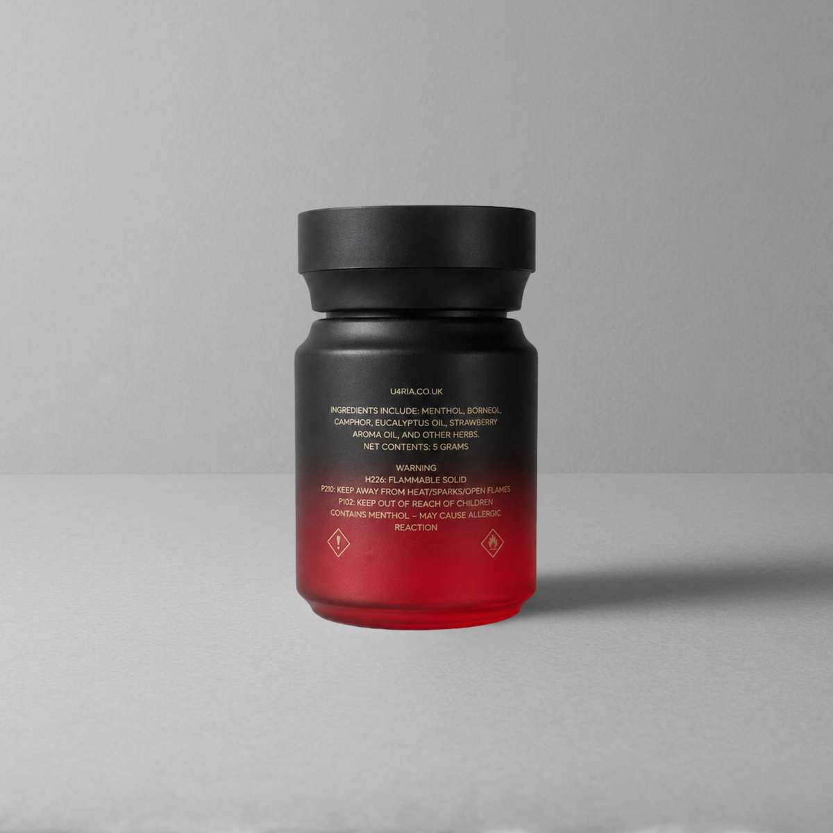 The back of a strawberry U4RIA bottle with a black cap and a black-to-red gradient body, shown on a plain light grey background. The bottle is photographed from the back, showing product text in gold.
