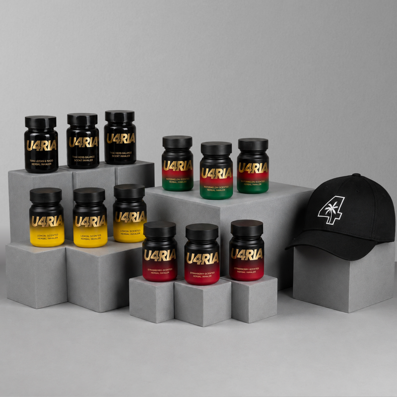 A styled product display featuring multiple U4RIA bottles in black, yellow, green, and red gradient labels, arranged on grey blocks next to a black baseball cap with a white '4' graphic logo, against a neutral grey background.