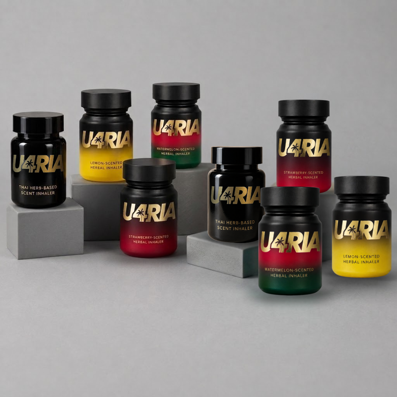 Eight U4RIA herbal inhalers, arranged on grey blocks against a neutral grey background. The bottles feature different colour gradients on their labels: yellow/lemon, red/strawberry, green and red/ watermelon, and black.