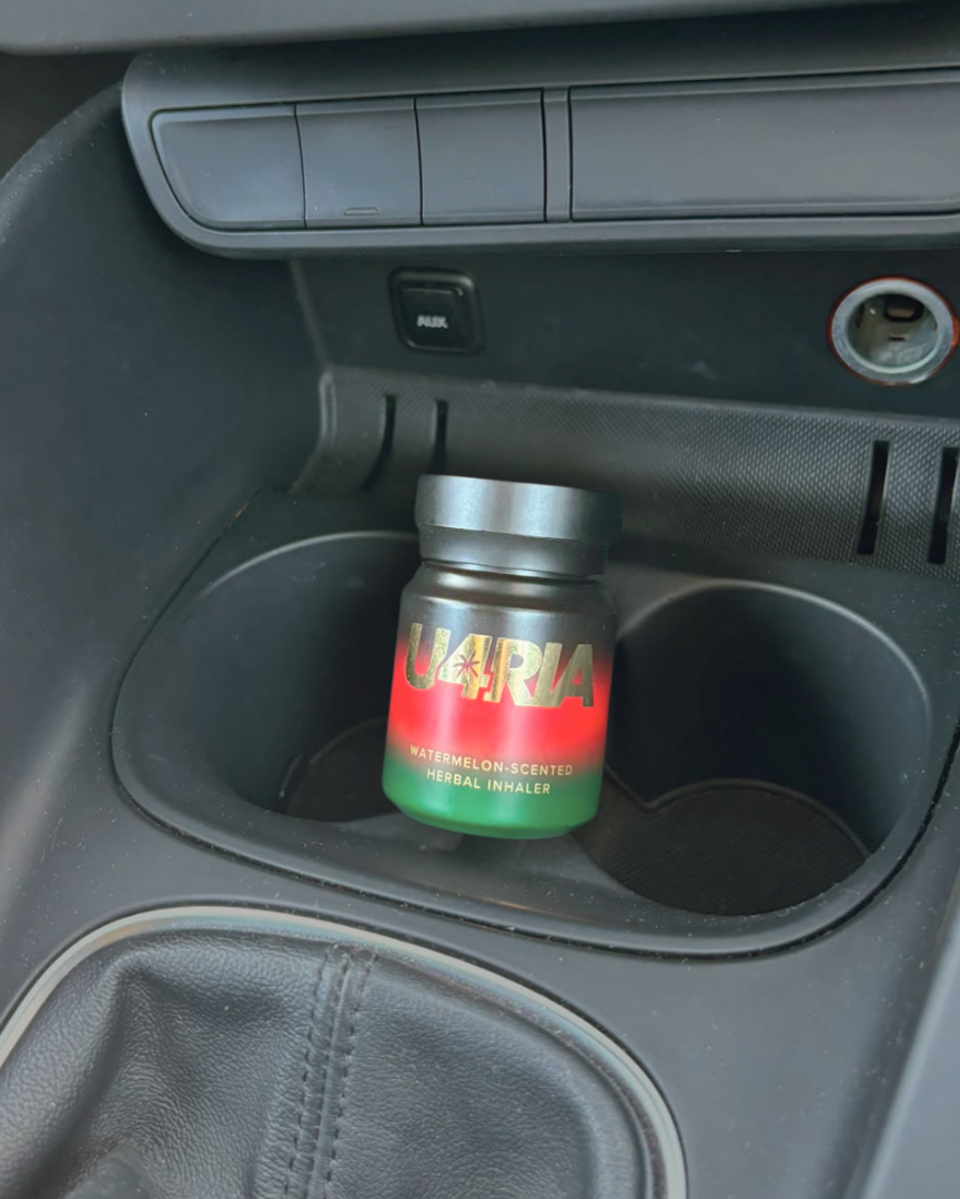 Watermelon-scented U4RIA herbal inhaler sitting in a car cup holder